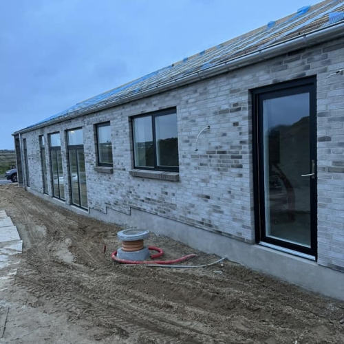 Nybyg-projekt i Skanderborg med store vinduespartier og moderne facade.