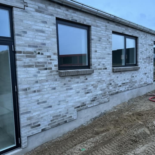 Nybyggeri i Skanderborg med moderne murstensfacade og sorte vinduesrammer.