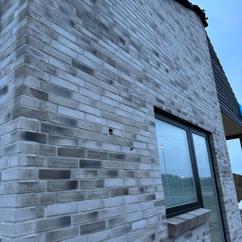 Facade på nybyggeri i Skanderborg med lyse mursten og sort vinduesramme.