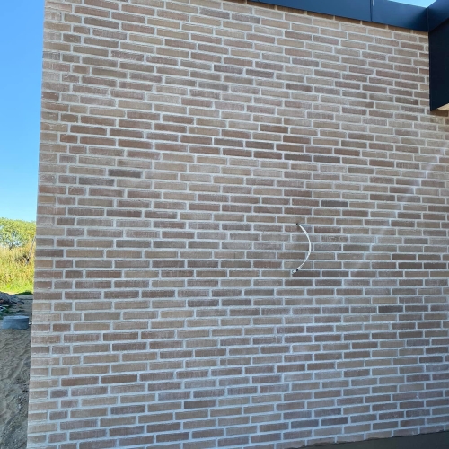 Nybyg i Aarhus med lys teglfacade og skjulte installationer.