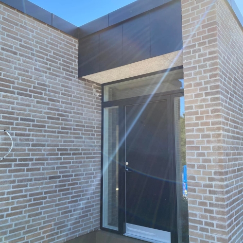 Indgangsparti til nybygget bolig i Aarhus med sorte facadeelementer.