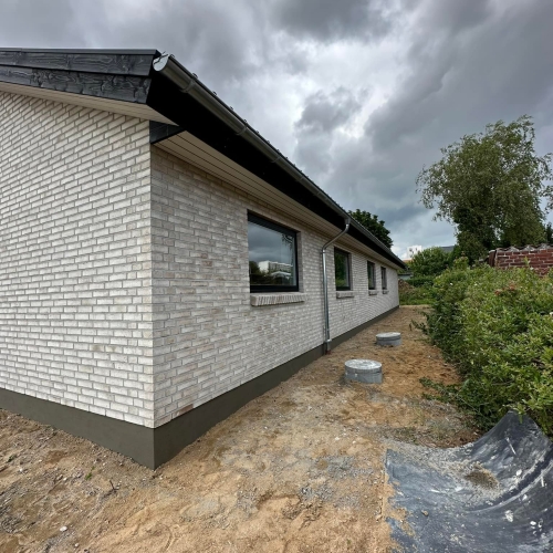 Nybyggeri i Silkeborg med synlig sokkel og facade i lyse mursten.