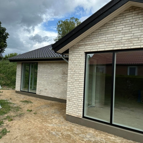 Hjørneløsning på nybyggeri i Silkeborg med lyse mursten og panoramavinduer.